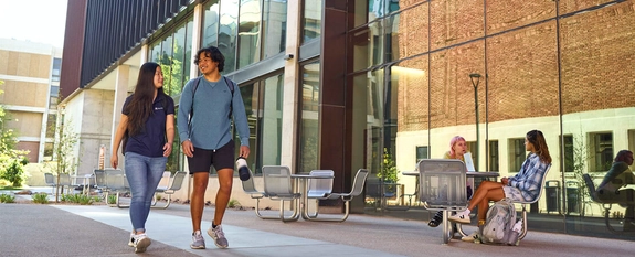 Two UArizona students walking outside on campus