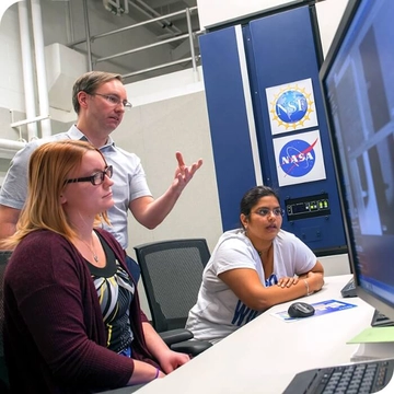NASA workers looking at a computer screen