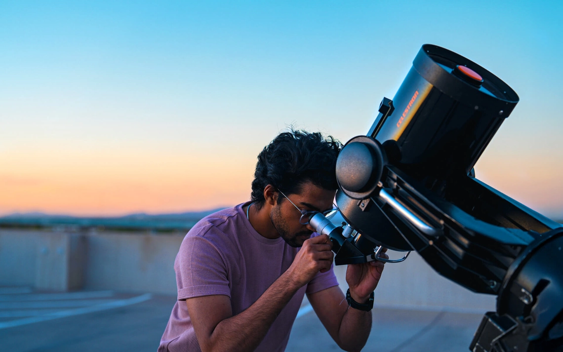 University of Arizona student looking into a telescope